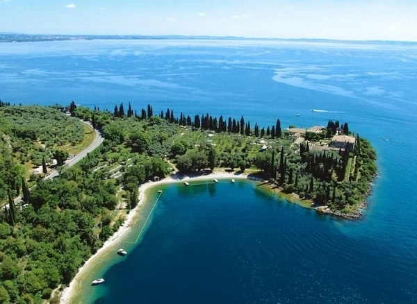 La Baia delle Sirene a Punta San Vigilio con la spiaggia e i cipressi