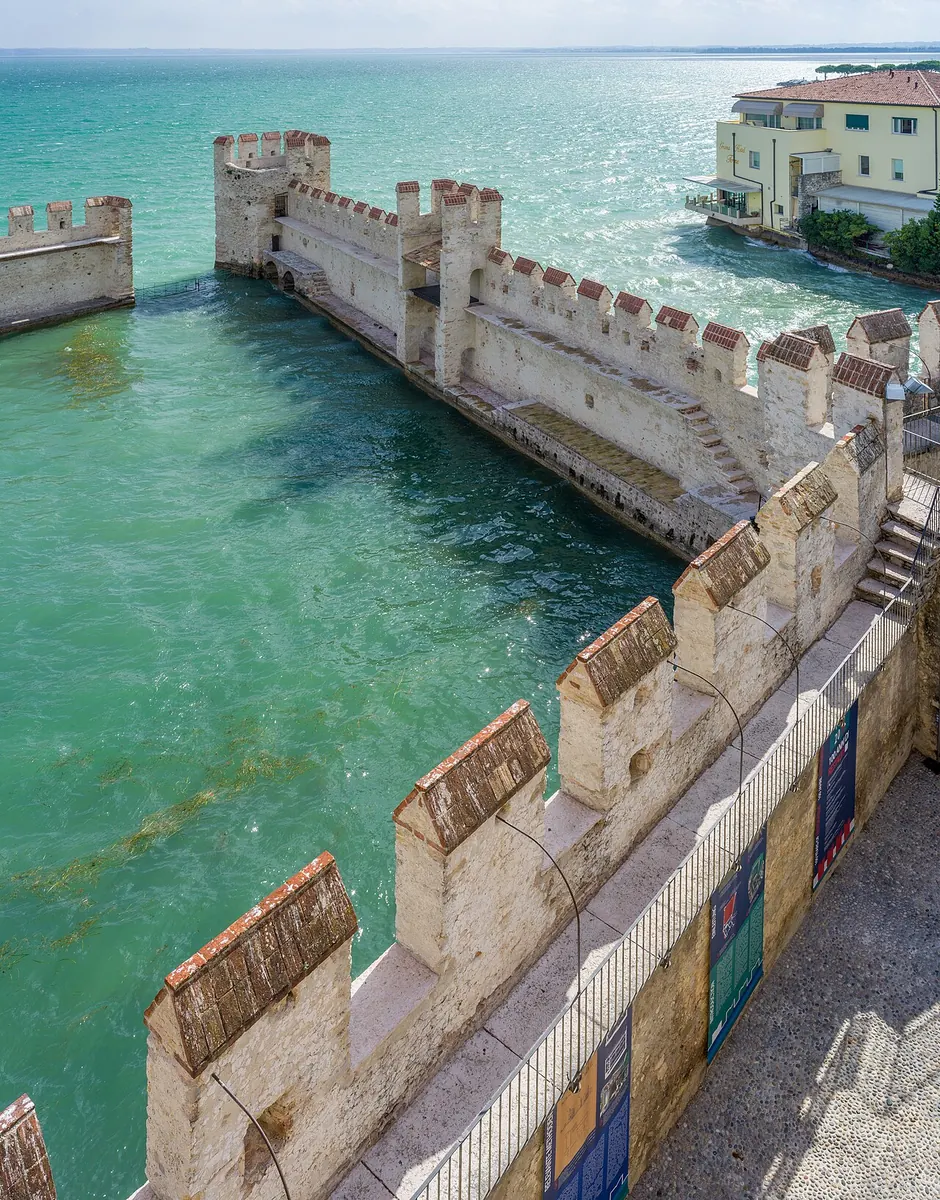 Il castello scaligero di Sirmione con la darsena e l'acqua turchese
